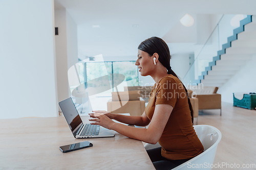 Image of Woman sitting in living room using laptop look at cam talk by video call with business friend relatives, head shot. Job interview answering questions.