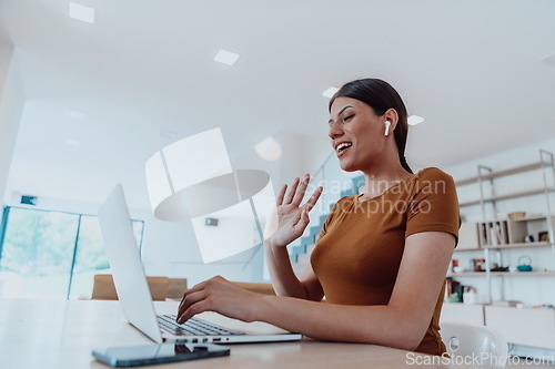 Image of Woman sitting in living room using laptop look at cam talk by video call with business friend relatives, head shot. Job interview answering questions.