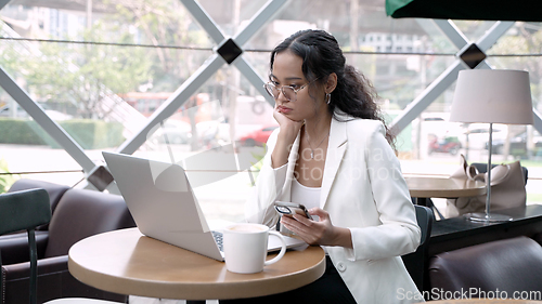 Image of Professional Woman Working Remotely with Wireless Technology in a Cozy Cafe