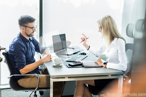 Image of Business meeting. Client consulting. Confident business woman, real estate agent, financial advisor explaining details of project or financial product to client in office.