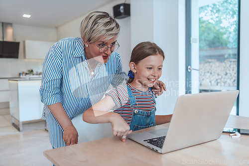 Image of Mother with her daughter talking on laptop with family and friends while sitting in modern living room of big house