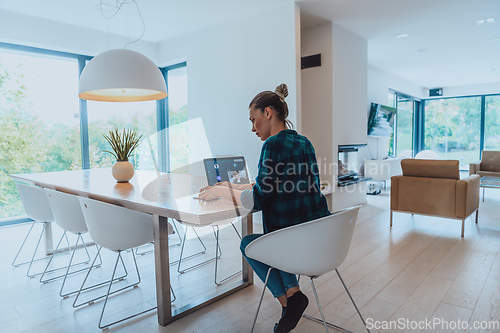 Image of Woman sitting in living room using laptop look at cam talk by video call with business friend relatives, head shot. Job interview answering questions.