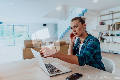 Image of Woman sitting in living room using laptop look at cam talk by video call with business friend relatives, head shot. Job interview answering questions.