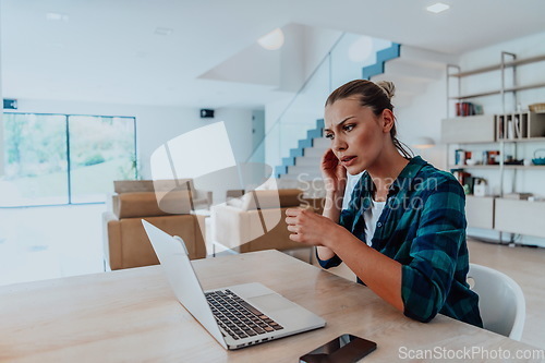 Image of Woman sitting in living room using laptop look at cam talk by video call with business friend relatives, head shot. Job interview answering questions.