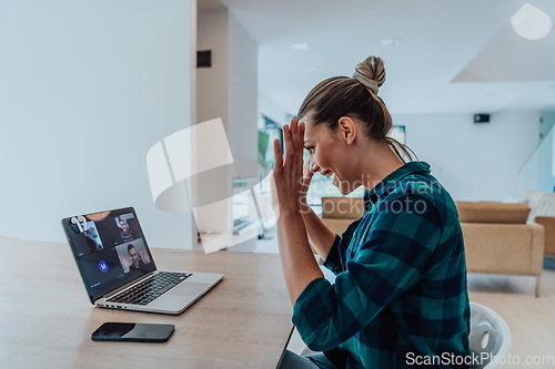 Image of Woman sitting in living room using laptop look at cam talk by video call with business friend relatives, head shot. Job interview answering questions.