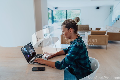 Image of Woman sitting in living room using laptop look at cam talk by video call with business friend relatives, head shot. Job interview answering questions.