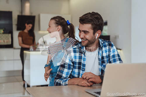 Image of Father and daughter in modern house talking together on laptop with their family during holidays. The life of a modern family