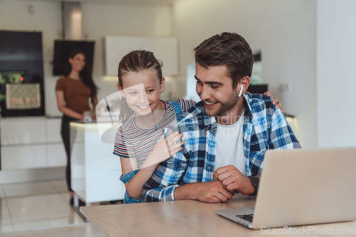 Image of Father and daughter in modern house talking together on laptop with their family during holidays. The life of a modern family