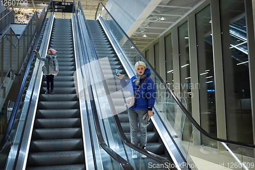 Image of Mother and child together on escalator background. Terminal, airport travel, love care.