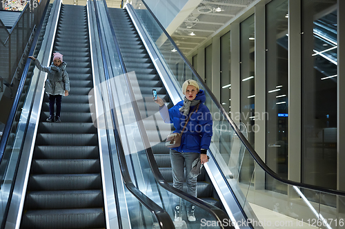 Image of Mother and child together on escalator background. Terminal, airport travel, love care.