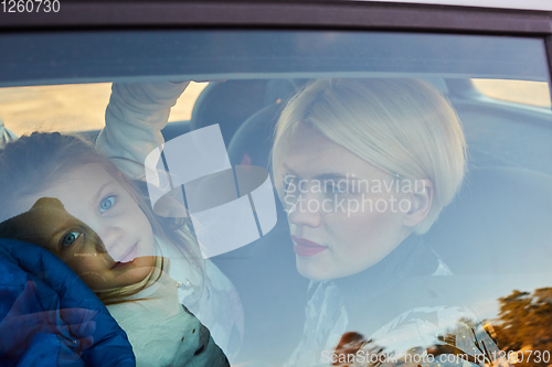 Image of Family concept. Portrait of mother and daughter through the glass of a car