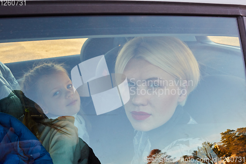 Image of Family concept. Portrait of mother and daughter through the glass of a car