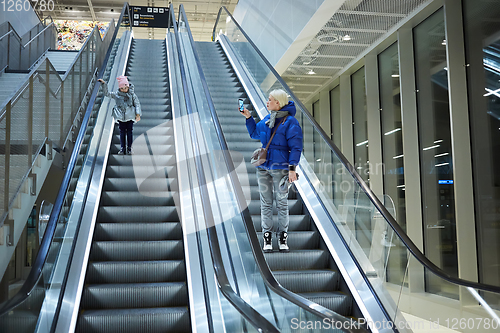 Image of Mother and child together on escalator background. Terminal, airport travel, love care.
