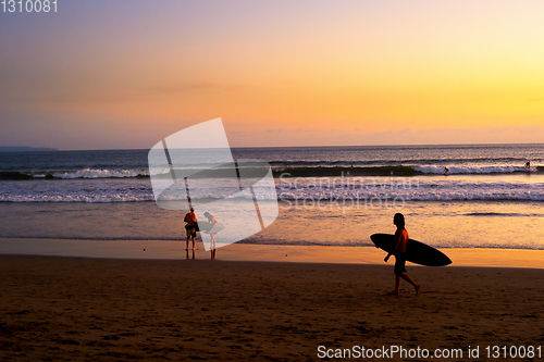 Image of Surfers on beach at sunset