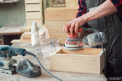 Image of Worker grinds the wood box