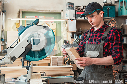 Image of Carpenter worker cutting wooden board