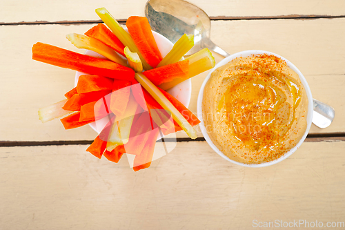 Image of fresh hummus dip with raw carrot and celery