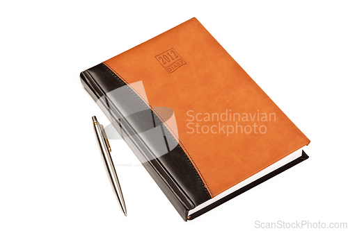 Image of Diary and pen on table isolated