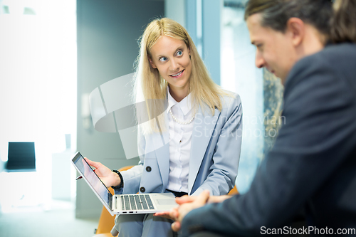 Image of Business meeting. Client consulting. Confident business woman, real estate agent, financial advisor explaining details of project or financial product to client in office.
