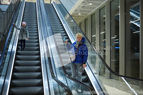 Image of Mother and child together on escalator background. Terminal, airport travel, love care.