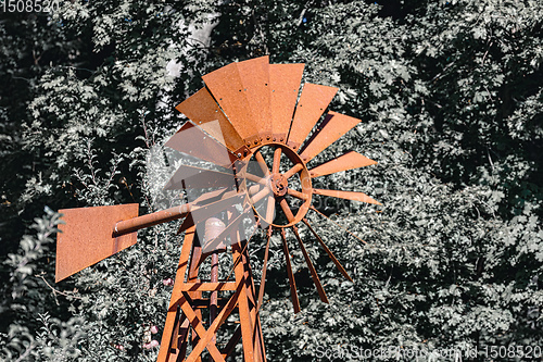 Image of Wind powered water pump with rusty pipes