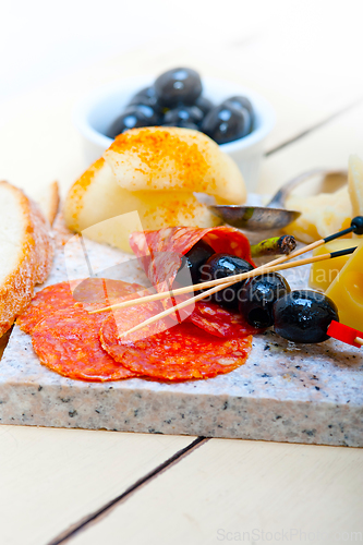 Image of mix cold cut on a stone with fresh pears