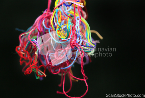 Image of Ball of multicolored tangled threads for needlework on black bac