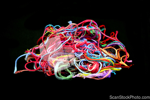 Image of Ball of multicolored tangled threads for needlework on black bac