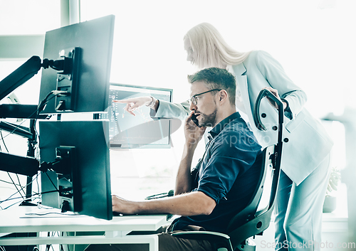 Image of Stock broker business team trading online watching charts and data analyses on multiple computer screens in modern corporate work station office.