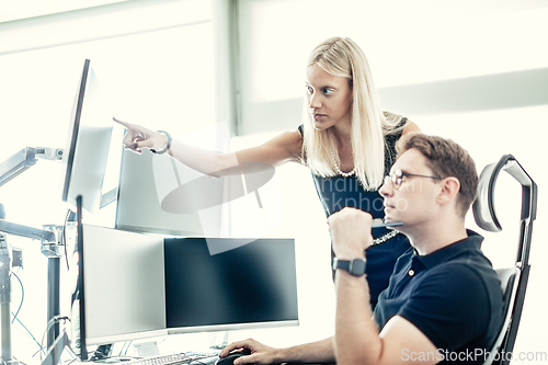 Image of Stock broker business team trading online watching charts and data analyses on multiple computer screens in modern corporate work station office.