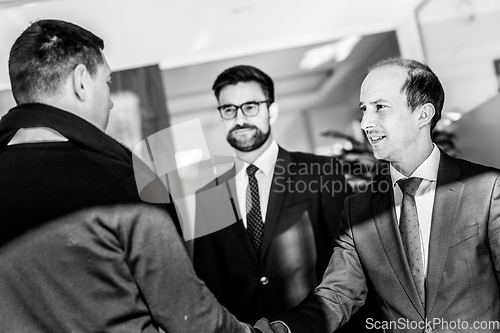 Image of Group of confident business people greeting with a handshake at business meeting in modern office or closing the deal agreement by shaking hands.