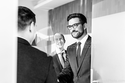 Image of Group of confident business people greeting with a handshake at business meeting in modern office or closing the deal agreement by shaking hands.