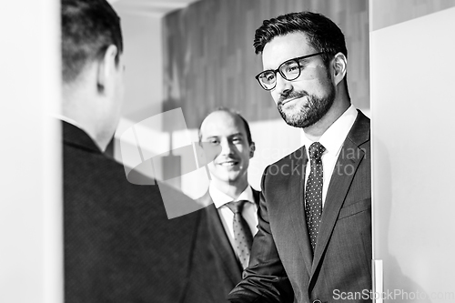 Image of Group of confident business people greeting with a handshake at business meeting in modern office or closing the deal agreement by shaking hands.