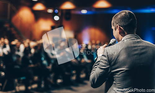 Image of Public speaker giving talk at Business Event.