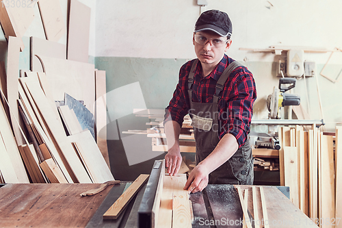 Image of Carpenter worker cutting wooden board