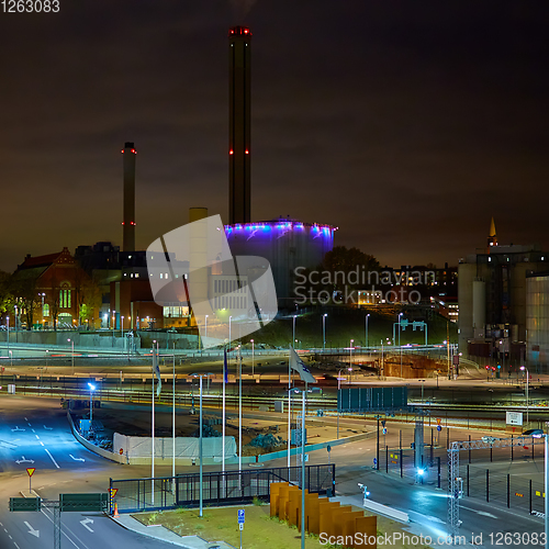 Image of Modern grain terminal at night. Metal tanks of elevator. Grain-drying complex construction. Commercial grain or seed silos at seaport. Steel storage for agricultural harvest