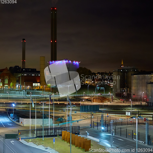 Image of Modern grain terminal at night. Metal tanks of elevator. Grain-drying complex construction. Commercial grain or seed silos at seaport. Steel storage for agricultural harvest