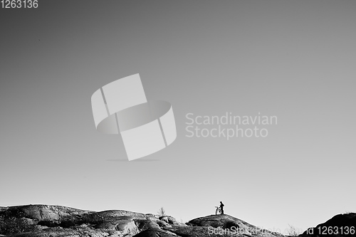 Image of Silhouette of young active man with bicycle standing and looking forward at mountains panoramic background