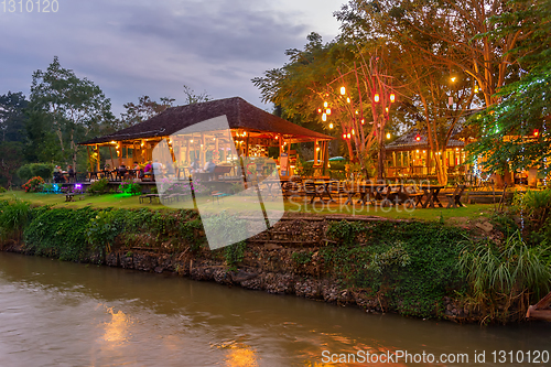 Image of Illuminated outdoor restaurant by river