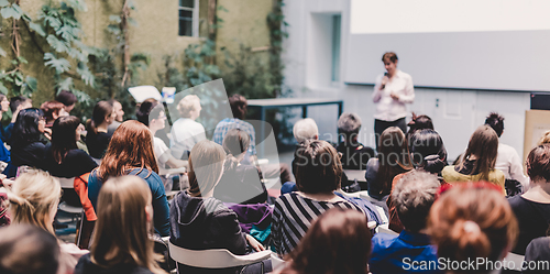 Image of Woman giving presentation in lecture hall at university.