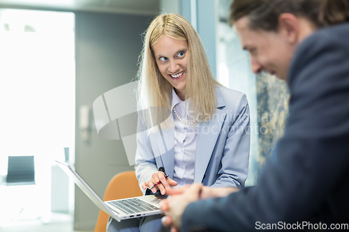 Image of Business meeting. Client consulting. Confident business woman, real estate agent, financial advisor explaining details of project or financial product to client in office.