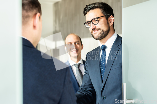 Image of Group of confident business people greeting with a handshake at business meeting in modern office or closing the deal agreement by shaking hands.