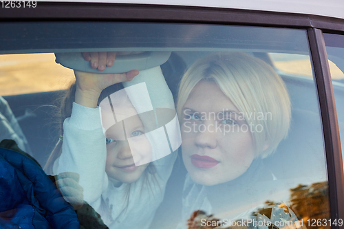 Image of Family concept. Portrait of mother and daughter through the glass of a car