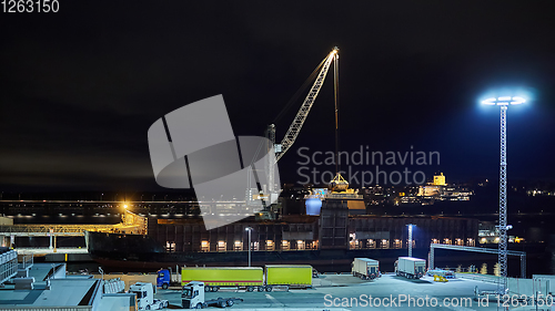 Image of mechanical hydraulic clamshell grabbers loading coal on ship at night.