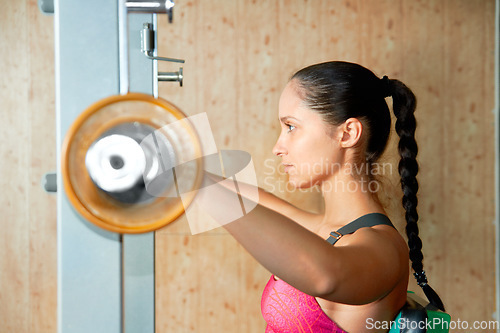 Image of Profile, woman and barbell exercise in gym for power, workout and strong bodybuilding with focus. Serious female athlete, weights and fitness training for healthy muscles, sports and strength in club