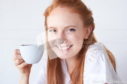 Image of Happy, smile and portrait of a woman with coffee in a studio in the morning on a weekend. Happiness, excited and face of a female model drinking a cappuccino, caffeine or latte by a white background.