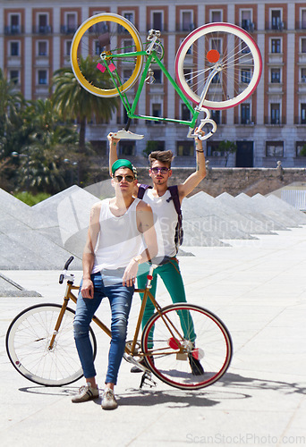 Image of Bicycle, men and friends in a city street with freedom, holiday or vacation, pose and attitude on urban background. Bike, cyclist and people outdoors for cycling, fitness and having fun in London