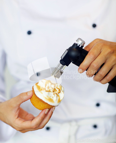 Image of Baker, torch and flame in restaurant for dessert, cake or meringue in kitchen for fine dining experience. Fire, cupcake and pastry chef in cafe, coffee shop or small business for cooking luxury food