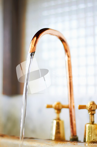 Image of Faucet, copper and tap with stream of water for cleaning, washing and hygiene in kitchen or bathroom. Plumbing, home decoration and closeup of running liquid, aqua and drops in basin for cleansing