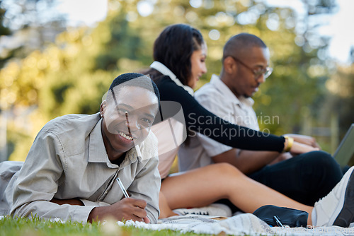 Image of Black man, student and writing with group in study, project or assignment on grass together in nature. Portrait of happy African male person or learner studying with team for education in the park